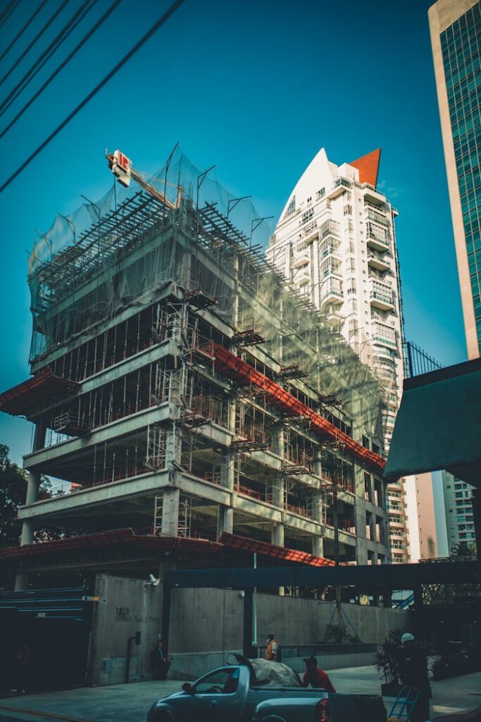 pexels-photo-2100681 High-rise building under construction with scaffolding and crane in urban cityscape.