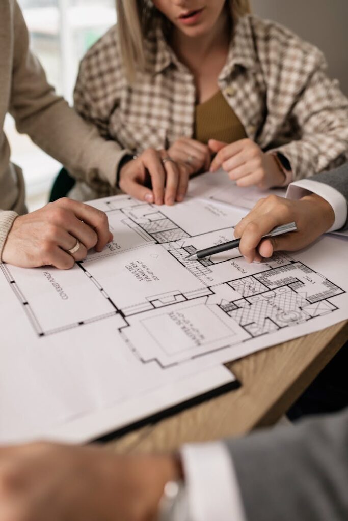 pexels-photo-7641854 People discuss architectural plans in a real estate planning session, highlighting teamwork.
